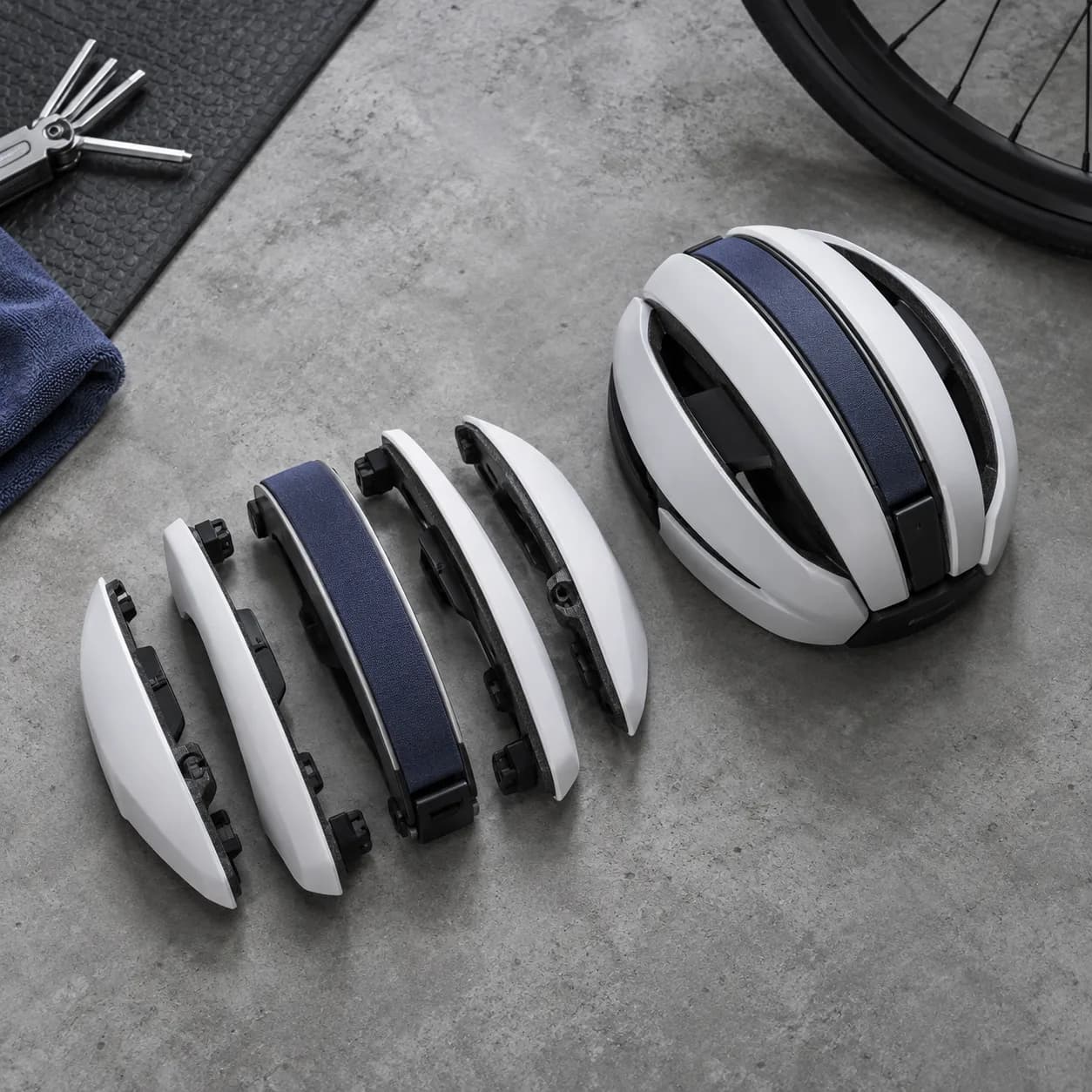 a folding bicycle helmet in matte concrete, clean cycle workshop
