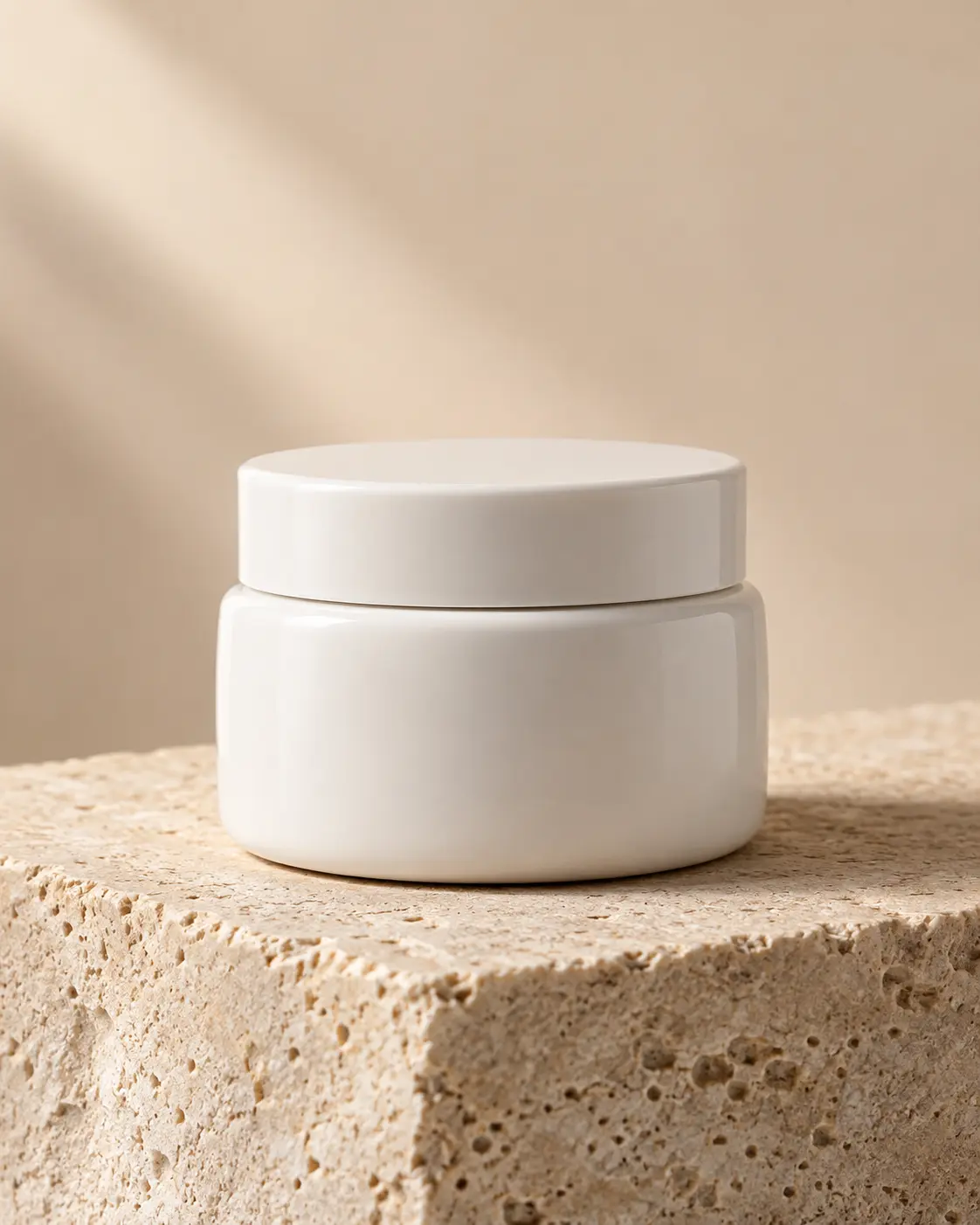 Unbranded white ceramic cosmetic jar on natural limestone in soft daylight